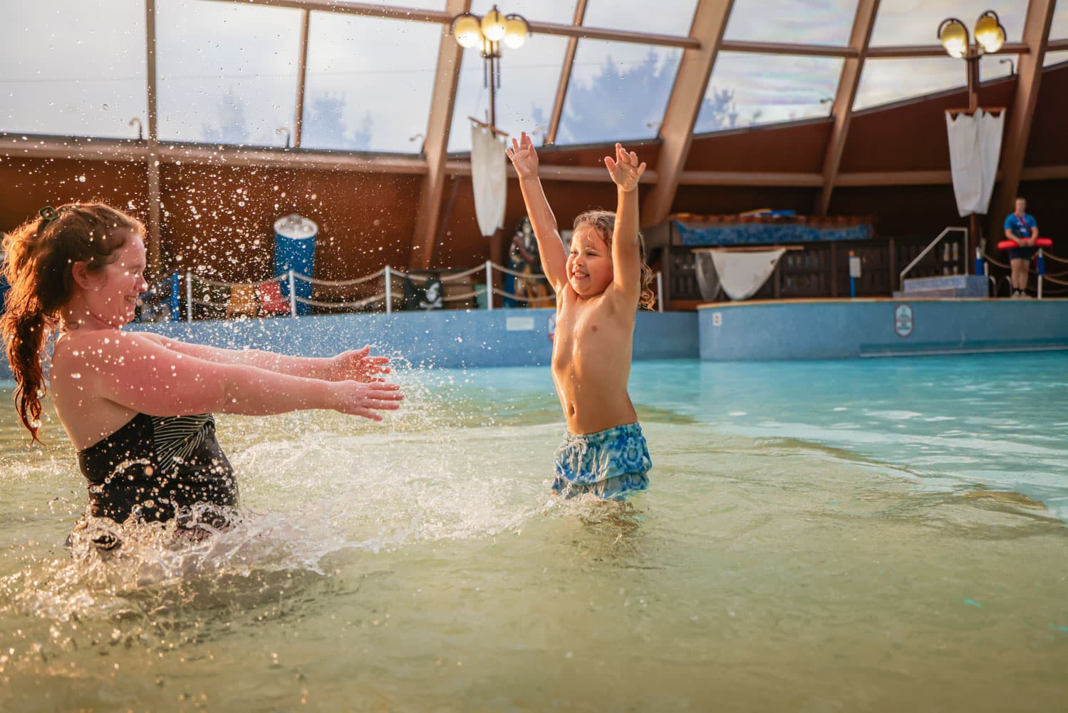 Mum & Son Splashing And Jumping In Blue Lagoon